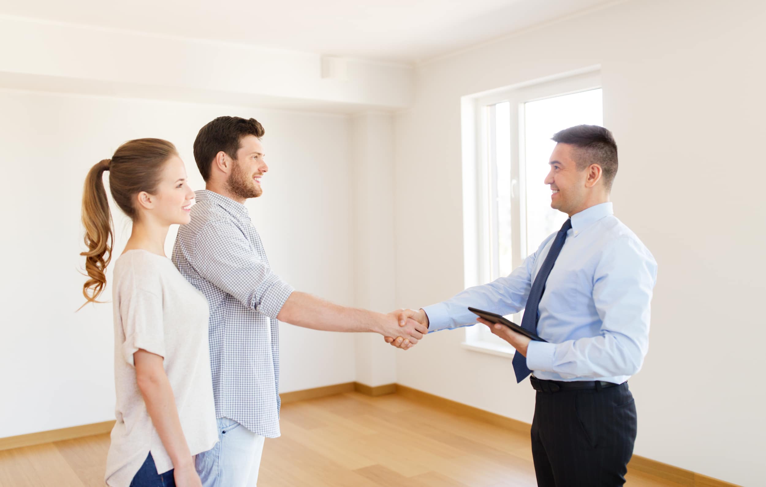 Property investors shaking hands with realtor after buying first rental property